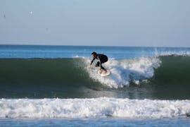 Een surfer rijdt op een golf tijdens een hele dag surfen in Espinho met Green Coast Espinho.