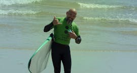 Een persoon die een surfplank vasthoudt tijdens surflessen in Espinho - Surf & Eten met Green Coast Espinho.