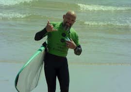 Clases de Surf en Espinho - Surf & Comer con Green Coast Espinho. Una persona sosteniendo una tabla de surf durante las clases de surf en Espinho - Surf & Eat with Green Coast Espinho.