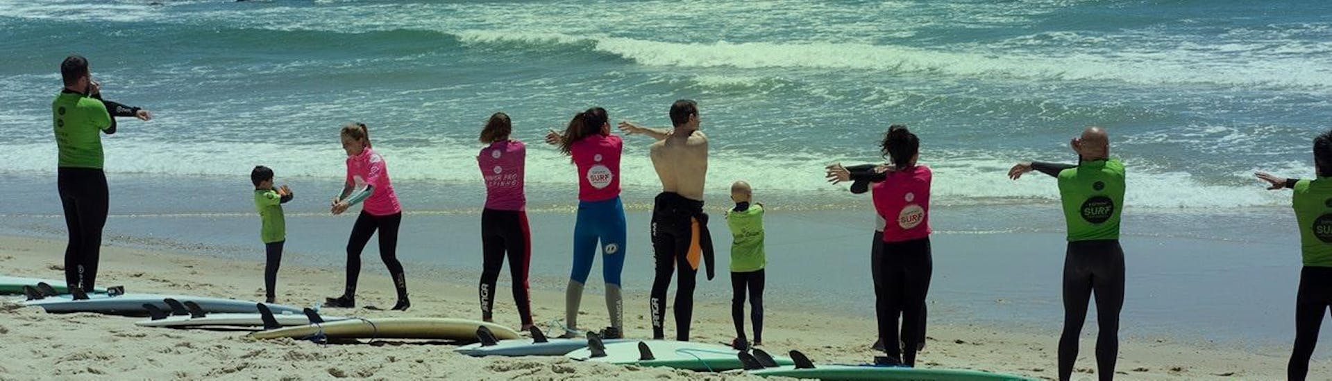 Een groep mensen op het strand tijdens surflessen voor kinderen en volwassenen in Espinho met Green Coast Espinho.