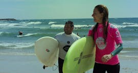 Twee mensen houden een surfplank vast tijdens surflessen voor kinderen en volwassenen in Espinho met Green Coast Espinho.