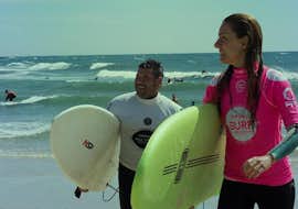 Clases de surf para niños y adultos en Espinho con Green Coast Espinho. Dos personas sosteniendo una tabla de surf durante las clases de surf para niños y adultos en Espinho con Green Coast Espinho.