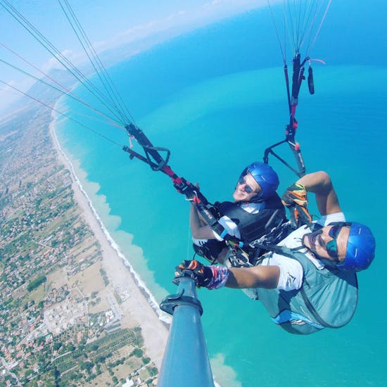 Two people smiling at the camera during the Tandem Paraglidingin San Vito lo Capo.