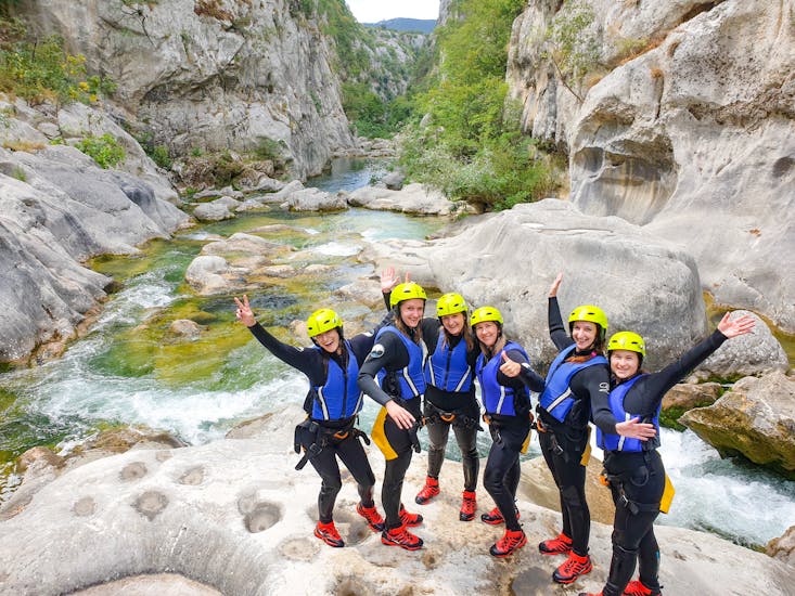 Een groep mensen van Iris Adventure Dalmatia canyoning op een rots bij de Cetina rivier.