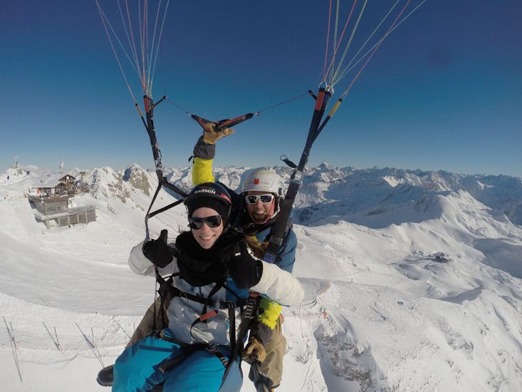 A woman during her Tandem Paragliding from Nebelhorn in Winter.