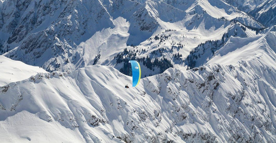 A tandem flying in the sky during Tandem Paragliding at Hörnerbahn in Winter - Panorama Flight with vogelfrei Allgäu.