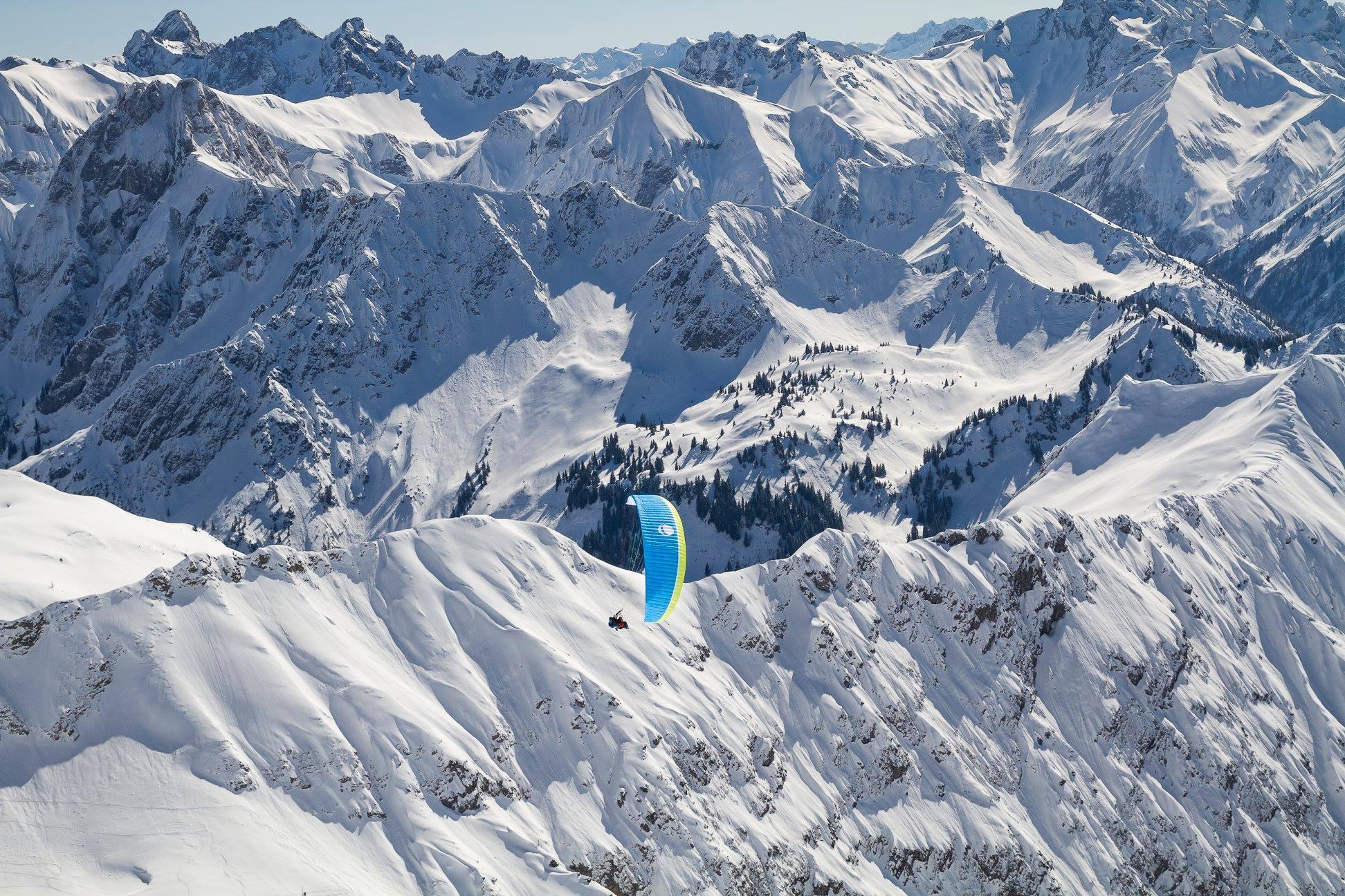 Een tandem vliegen tijdens Tandem Paragliding bij Hörnerbahn in de winter - Panorama Plus met vogelfrei Allgäu.