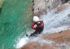 A man is sliding down a very steep waterslide during the Canyoning "Sport & Aquatic" - Canyon de la Vacca organised by professionals from Acqua et Natura.