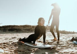 A girls is practicing her stands with an instructor in her private surfing lessons in Valencia with Anywhere Watersports.