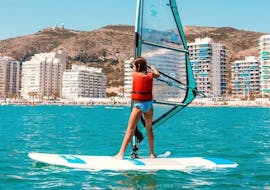 A girl is soaring the waters of the Mediterranean Sea while on her private windsurfing lessons in Valencia with Anywhere Watersports.