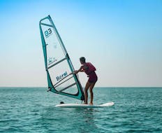 A man is standing up for the first time in the water with his windsurfing lessons in Cullera for beginners from Anywhere Watersports.