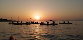 Een groep kajakken onder de zonsondergang tijdens de Sunset Sea Kayaking rond Lokrum Island met Swim Break met Adventure Dalmatia Dubrovnik.
