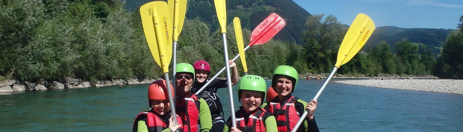 eine Gruppe in einem Boot beim Rafting auf der Iller in Blaichach für Kids & Families mit dem Outdoorzentrum Allgäu.