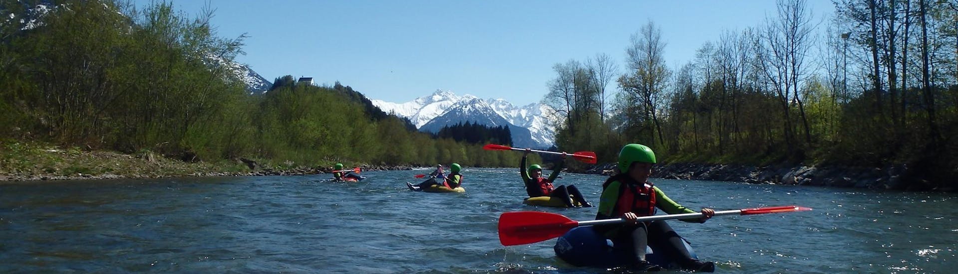 A couple of people on tubes in the water during tubing on the Iller River in the Allgäu with Outdoorzentrum Allgäu.