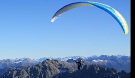 Ein Tandem Paraglider in der Luft über den Bergen während des Tandem Paragliding von der Jöchelspitze - Thermikflug mit onair Paragliding Center Tirol.