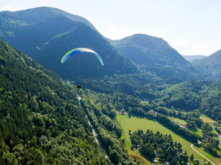 Ein Tandem Paraglider gleitet über die Berge während des Tandem Paragliding von der Jöchelspitze - Thermikflug mit onair Paragliding Center Tirol.