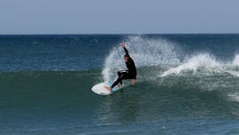 A guy surfing on the waves during Surfing Lessons for Kids & Adults all Levels with Zambeachouse Lourinhã.