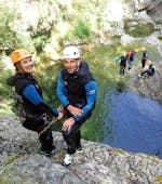 Two friends are getting ready to do an abseiling descent during their Canyoning in Gorges du Loup - Level 2 tour with FunTrip.