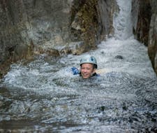 Un appassionato di canyoning nuota in una piscina naturale durante il trekking fluviale per famiglie nel canyon de la Basse Besorgues con Les Intraterrestres.