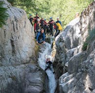 A canyoning enthusiast is going down a natural slide during their Canyoning "Discovery Day" - Canyon de la Haute Borne with Les Intraterrestres.