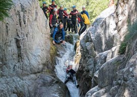 Ein Canyoning-Enthusiast rutscht während des Canyoning "Discovery Day" eine natürliche Rutsche hinunter - Canyon de la Haute Borne mit Les Intraterrestres.