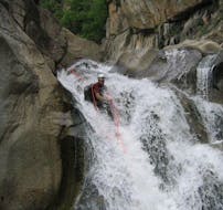 Un amateur de canyoning fait de la descente en rappel pendant sa sortie Canyoning "Journée Sportive" - Canyon du Haut Chassezac avec Les Intraterrestres.