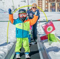 Un enfant emprunte le tapis roulant pendant son Cours de ski Enfants "Petits Ours" (3-4 ans) - Max 6 par groupe avec Prosneige Val Thorens & Les Menuires.