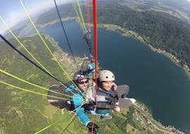A pilot with a passenger while Tandem Paragliding from Gerlitzen - Thermal Flight with Adventure-Wings Ossiachersee.