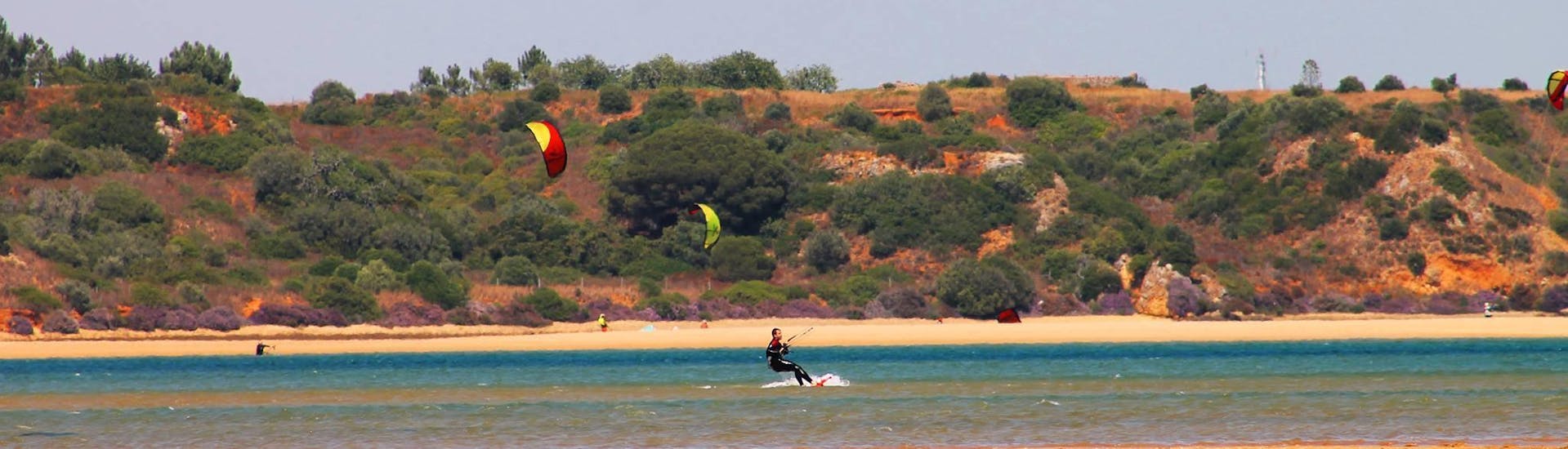 Ein Mann hat Spaß während des halbprivaten Kitesurfing-Kurses in Paaren - Alle Levels.