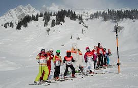 Kinderen nemen enkele Kinderskilessen voor gevorderde skiërs bij de skischool Stuben. 