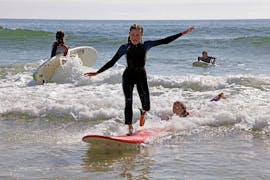 Ein junges Mädchen steigt nach ihrer Privater Surfkurs am Praia da Galé in Albufeira mit SUPA Surf School Albufeira.