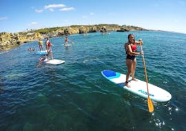 Some friends are paddling on the Praia da Coelha during a guided tour provided by SUPA Sea Adventures Algarve.