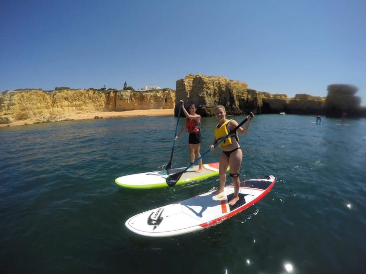 Deux amis pagaient sur la Praia da Coelha pendant une balade guidée proposée par SUPA Sea Adventures Algarve.