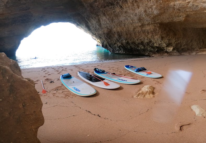 Die Boards liegen auf dem Sand, als wir die Höhlen während der geführten Stand Up Paddle Tour zu den Benagil Höhlen mit SUPA Sea Adventures Algarve erkunden.