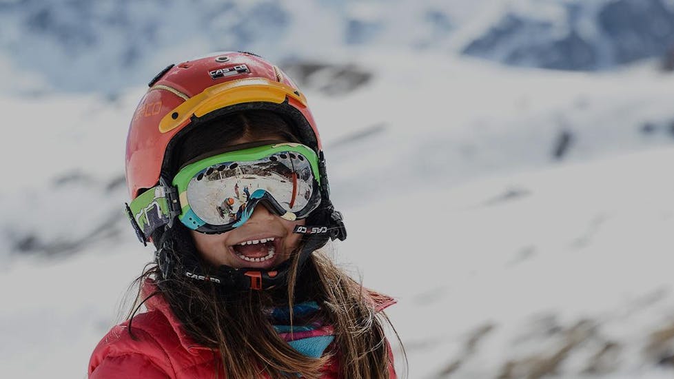A little girl is having fun with other children in the Kids Ski Lessons (5-13 years) - All Levels organised by the ski school Prosneige Val d'Isère.