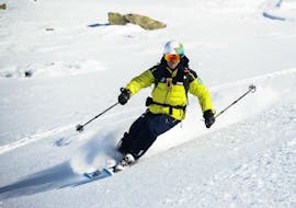 Un skieur descend une pente parfaitement lisse pendant son Cours de ski pour Adultes – Tous niveaux sous le regard attentif de son moniteur de ski de l'école de ski Prosneige Val d'Isère.