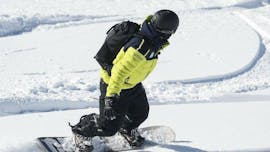 With a help of a professional instructor from the ski school Prosneige Val d'Isère, a snowboarder is quickly improving his technique and smoothing turns during the Snowboarding Lessons (from 8 y.) - Low Season.
