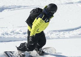 With a help of a professional instructor from the ski school Prosneige Val d'Isère, a snowboarder is quickly improving his technique and smoothing turns during the Snowboarding Lessons (from 8 y.) - Low Season.