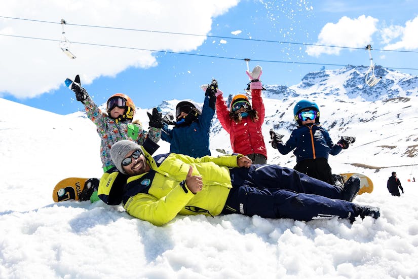 De jeunes snowboardeurs apprennent le snowboard pendant leur Cours de snowboard pour Enfants - Tous niveaux tout en s'amusant avec leur moniteur de l'école de ski Prosneige Val d'Isère.