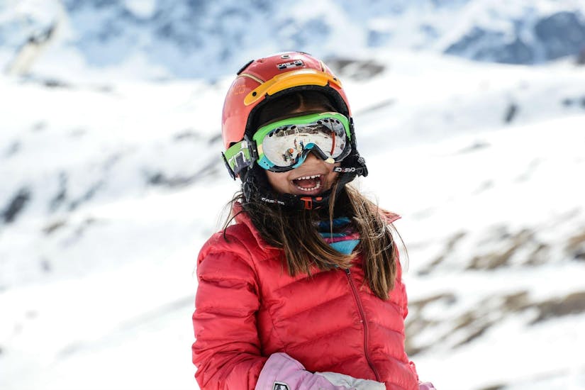 A little girl is having fun while learning how to ski during the Private Ski Lessons for Kids - High Season - All Ages that the team of Prosneige Val d'Isère tailored according to her needs.