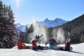 Niños divirtiéndose con la nieve polvo durante un descanso en su clase de snowboard con 360 Avoriaz.