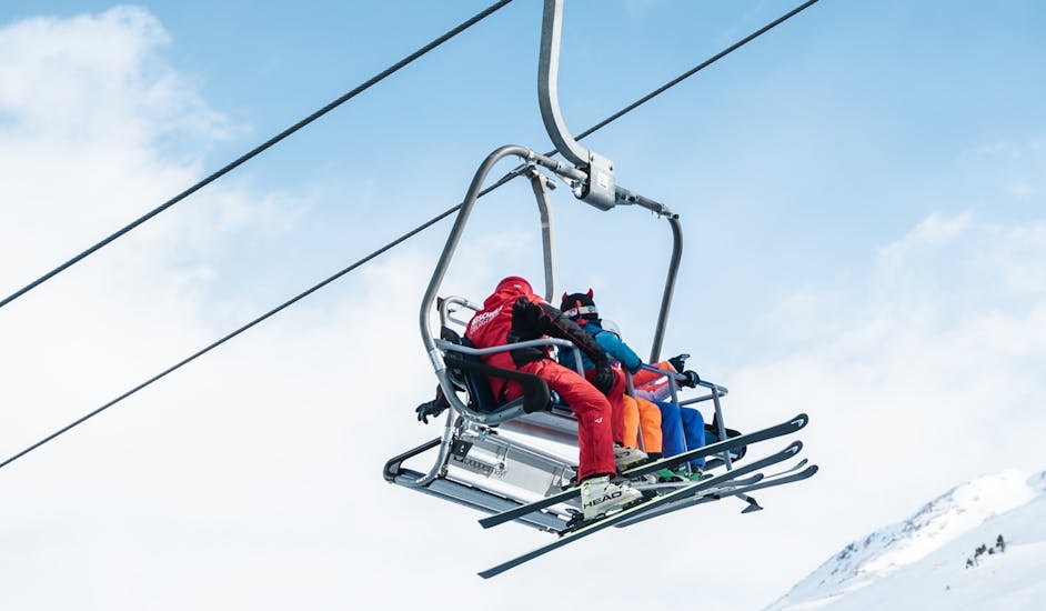 Skifahrer fahren mit dem Lift beim Privaten Skikurs für Erwachsene für alle Levels.