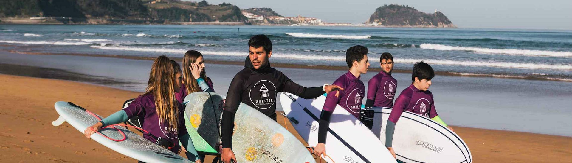 Eine Gruppe von Surfern ist bereit, die Lektion während des privaten Surfunterrichts für Kinder und Erwachsene - Alle Levels mit Shelter Surf Eskola von Aritz Aranburu zu beginnen.