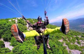 A participant enjoying a paragliding experience over Bjelopolje during a tandem paragliding activity with Sky Riders Paragliding Croatia.