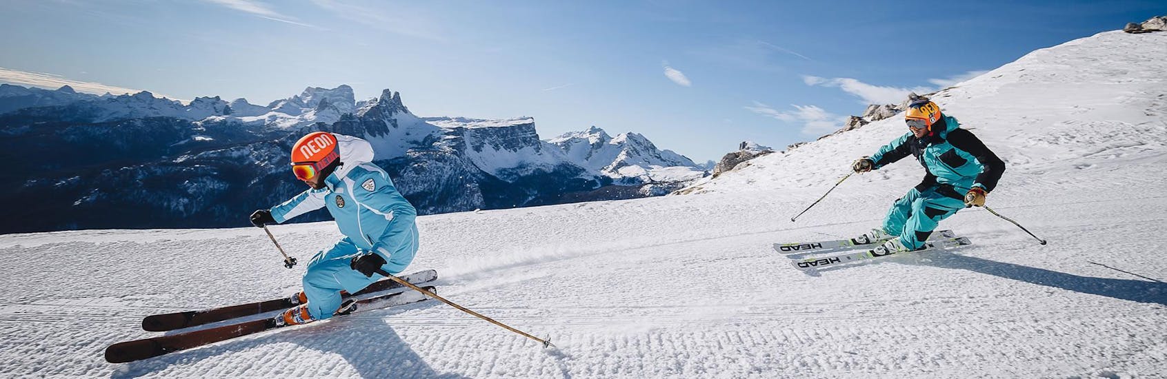 Un moniteur de ski montre le chemin sur une piste de ski dans la station de ski de Cortina d'Ampezzo pendant un des cours particuliers de ski pour adultes - VIP organisés par l'école de ski Scuola di Sci e Snowboard Cristallo Cortina.