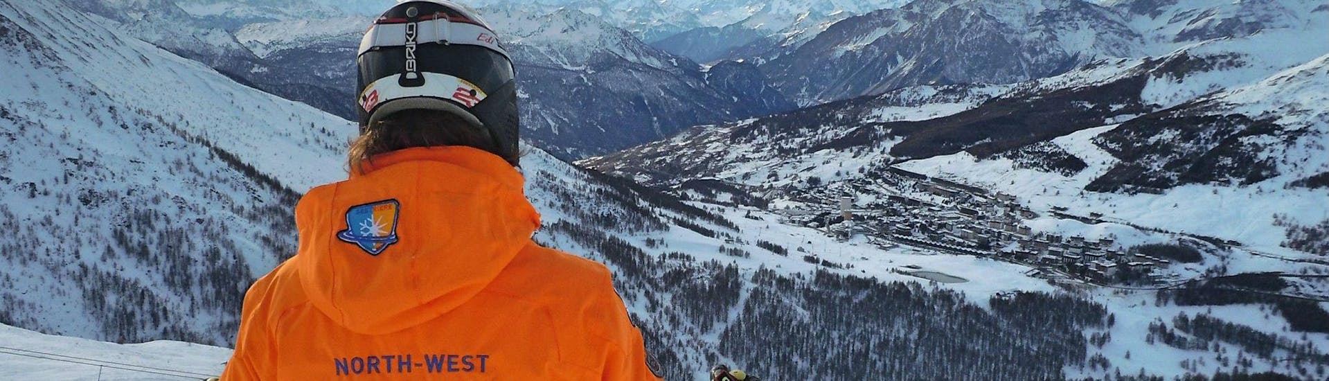 Uno sciatore sta ammirando le cime innevate del comprensorio sciistico di Sestriere durante una delle Lezioni di sci per adulti - Intermedi/Avanzati organizzate dalla scuola di sci YES Academy Sestriere.