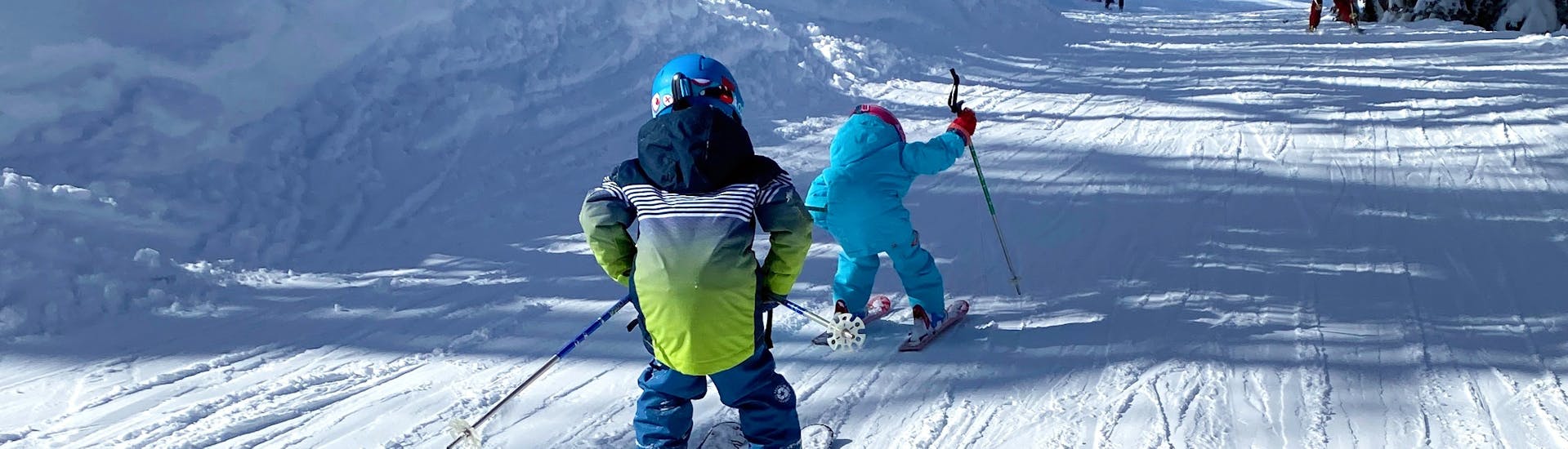 A kid is skiing down their first slope during their Private Ski Lessons for Kids (3-5 y.) with Evolution 2 Peisey Vallandry.