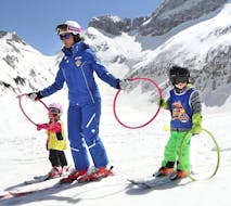 Ski instructors with two small kids on the slopes of Andalo for one of the kids ski lessons for beginners baby weekend.