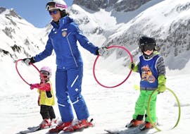 Ski instructors with two small kids on the slopes of Andalo for one of the kids ski lessons for beginners baby weekend.