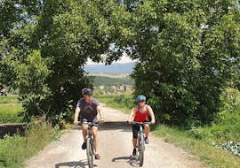 A couple is enjoying the Fun Bike Tour from Sinj with a certified guide from Hotel Alkar.
